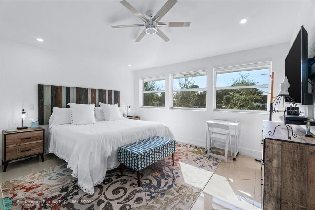 2058 Northwest 52nd Street Boca Raton, FL 33496 - Photo 16 of 35 a spacious bedroom with a bed a window and a flat screen television