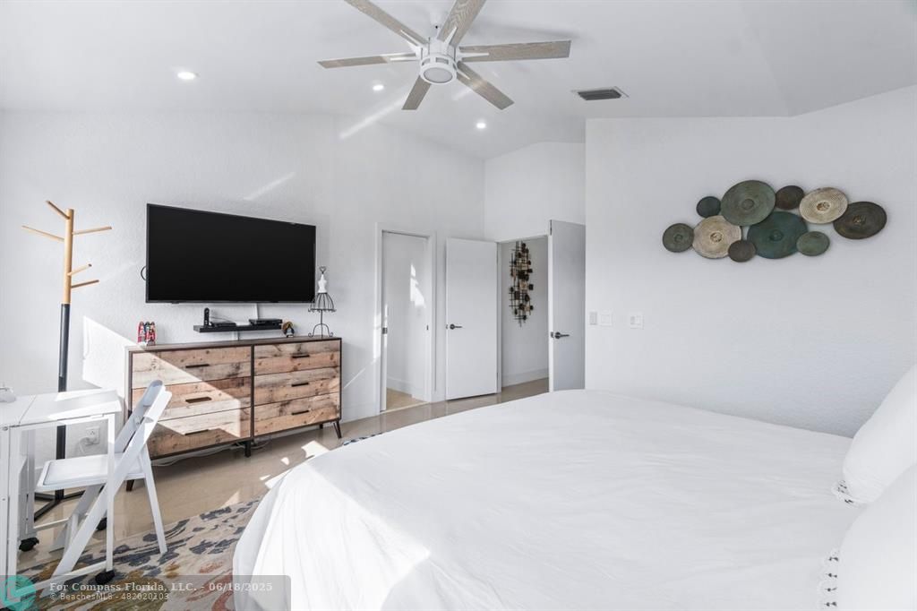 2058 Northwest 52nd Street Boca Raton, FL 33496 - Photo 17 of 35 a bedroom with a bed and flat tv screen on the dresser