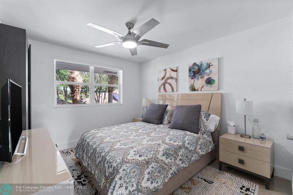 2058 Northwest 52nd Street Boca Raton, FL 33496 - Photo 22 of 35 a bedroom with a bed and a chandelier