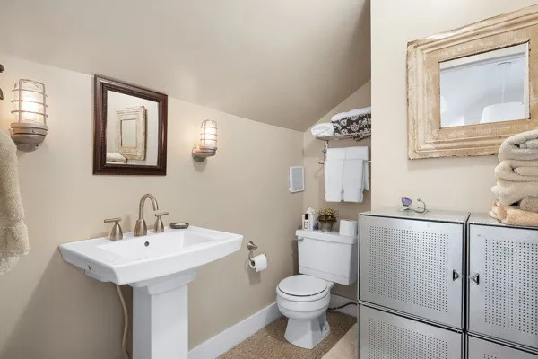 a bathroom with a sink a toilet and mirror