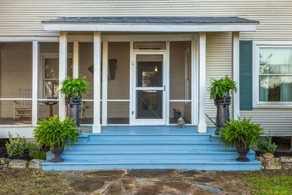 a view of front door deck and potted plants