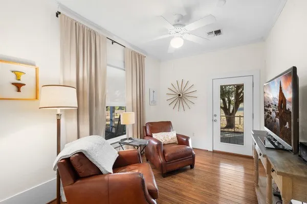 a living room with furniture a flat screen tv and a large window