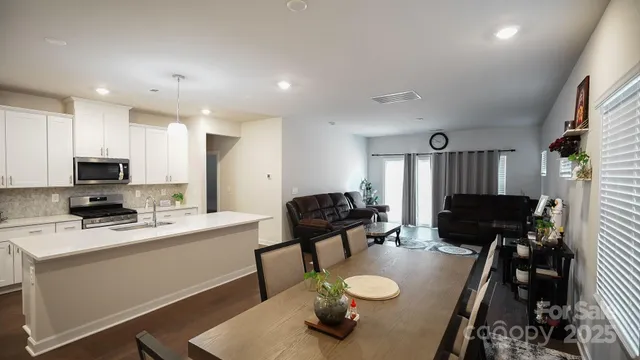 a kitchen with a sink dishwasher a refrigerator and a stove with wooden floor