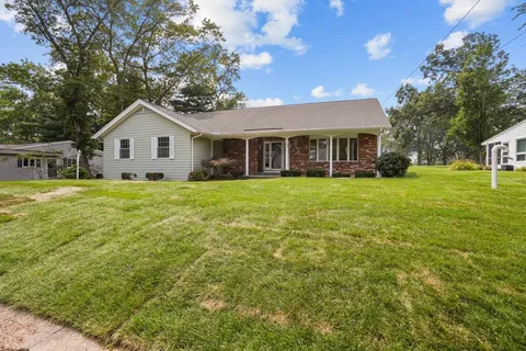 a view of a house with a big yard and palm trees