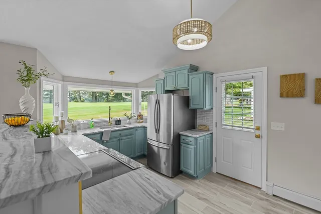 a kitchen with stainless steel appliances granite countertop a sink a stove and refrigerator