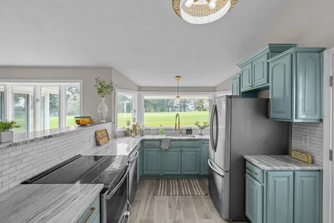 a kitchen with a sink a refrigerator a stove and wooden cabinets