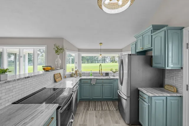 a kitchen with a sink a refrigerator a stove and wooden cabinets