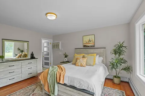 a bedroom with a bed and a potted plant on dresser