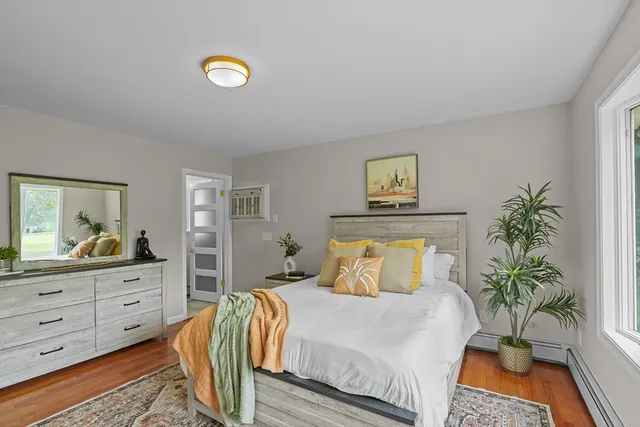 a bedroom with a bed and a potted plant on dresser