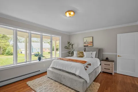 a bedroom with a bed and wooden floor
