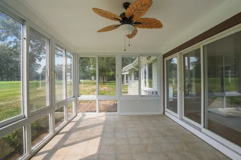 a view of a room with a ceiling fan and windows