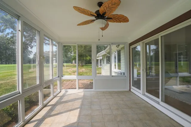 a view of a room with a ceiling fan and windows
