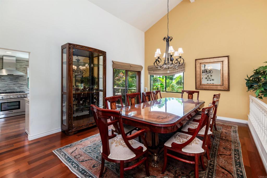 6541 Vispera Place Carlsbad, CA 92009 - Photo 12 of 54 a dining room with furniture a chandelier and wooden floor