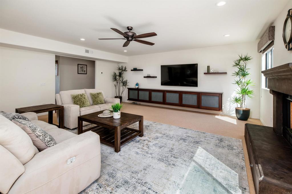 6541 Vispera Place Carlsbad, CA 92009 - Photo 14 of 54 a living room with furniture a flat screen tv and a fireplace
