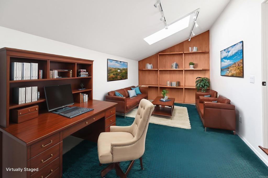 6541 Vispera Place Carlsbad, CA 92009 - Photo 27 of 54 a living room with furniture a rug and a bookshelf