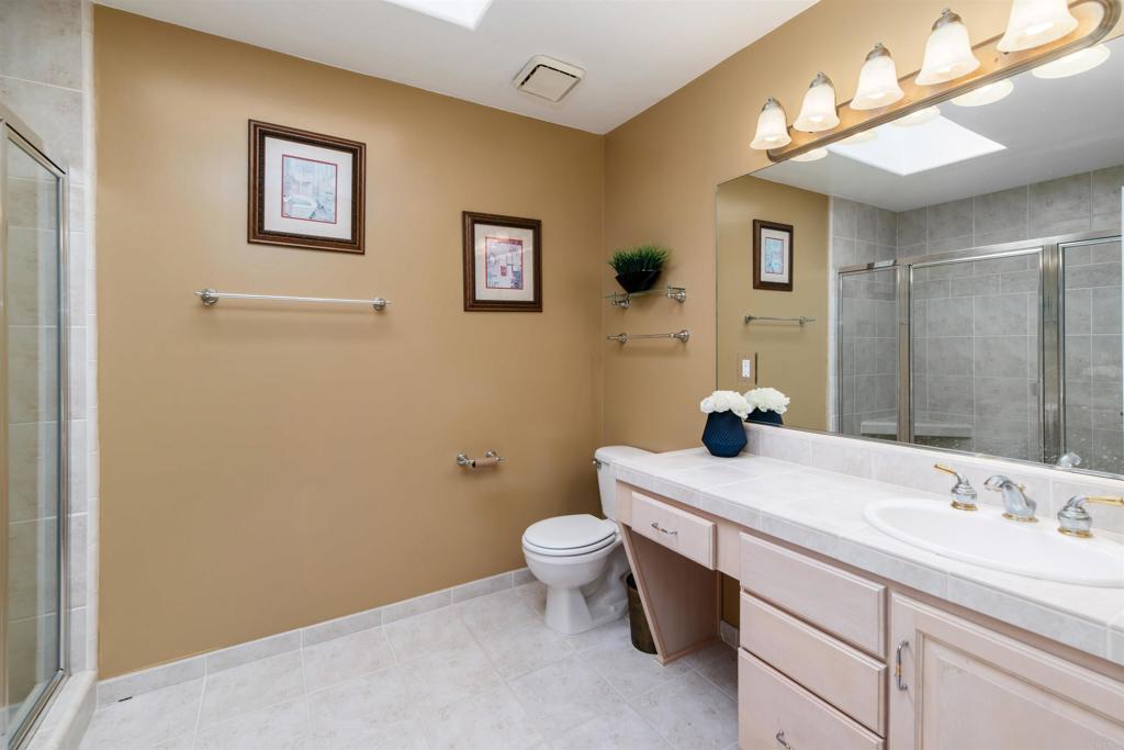 6541 Vispera Place Carlsbad, CA 92009 - Photo 33 of 54 a bathroom with a sink mirror vanity and toilet