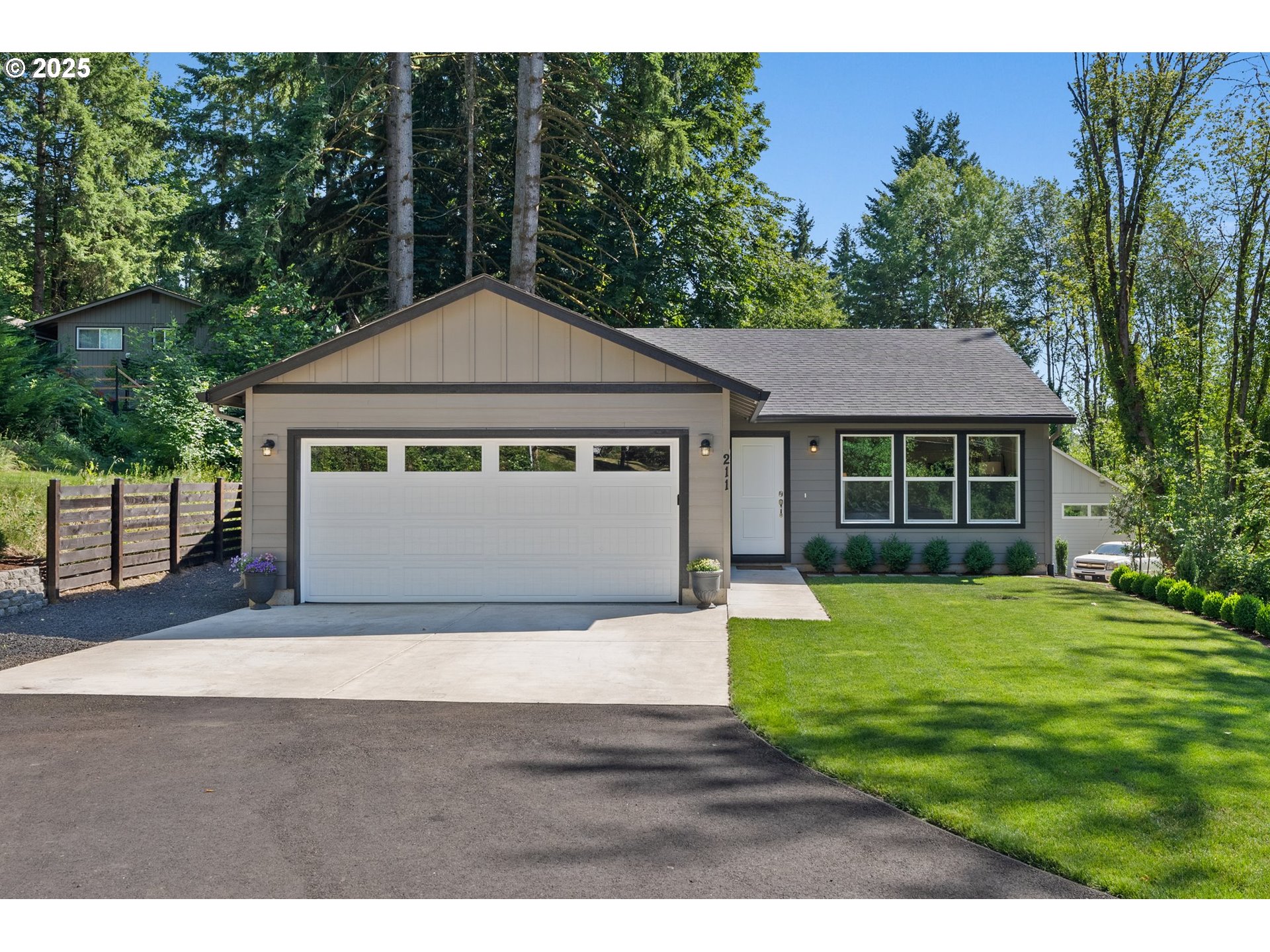a front view of a house with a yard and trees