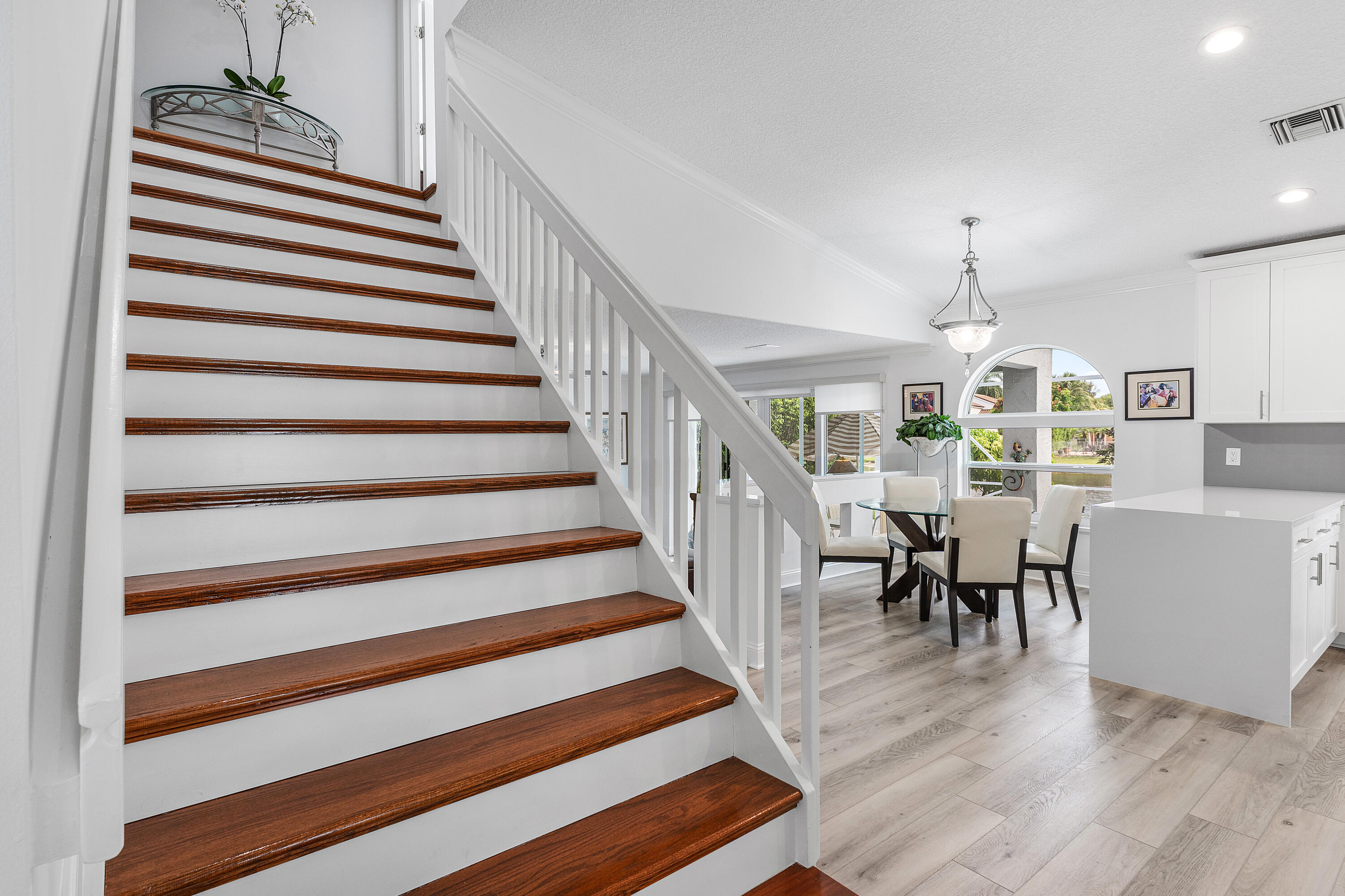 10824 Tea Olive Lane Boca Raton, FL 33498 - Photo 12 of 76 a view of a dining room with wooden floor and white walls