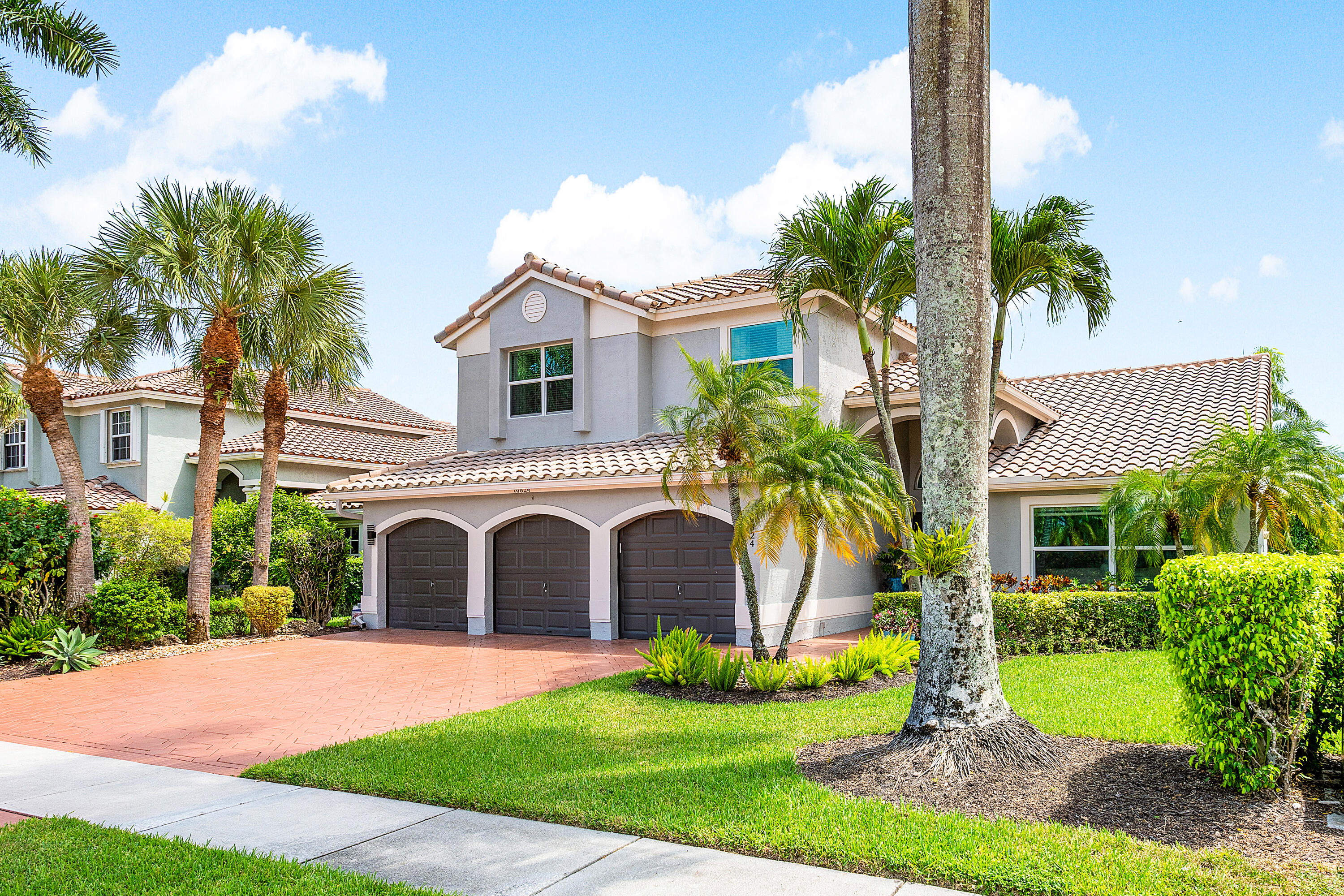10824 Tea Olive Lane Boca Raton, FL 33498 - Photo 2 of 76 a front view of a house with a garden and plants