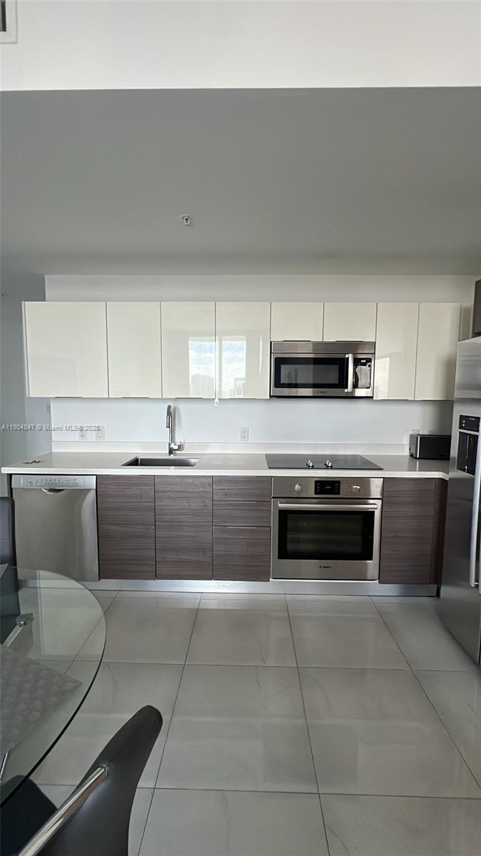 Brickell Miami, FL 33130 - Photo 2 of 12 a kitchen with stainless steel appliances a stove a sink and white cabinets