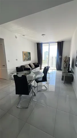 a living room with furniture a flat screen tv and a window