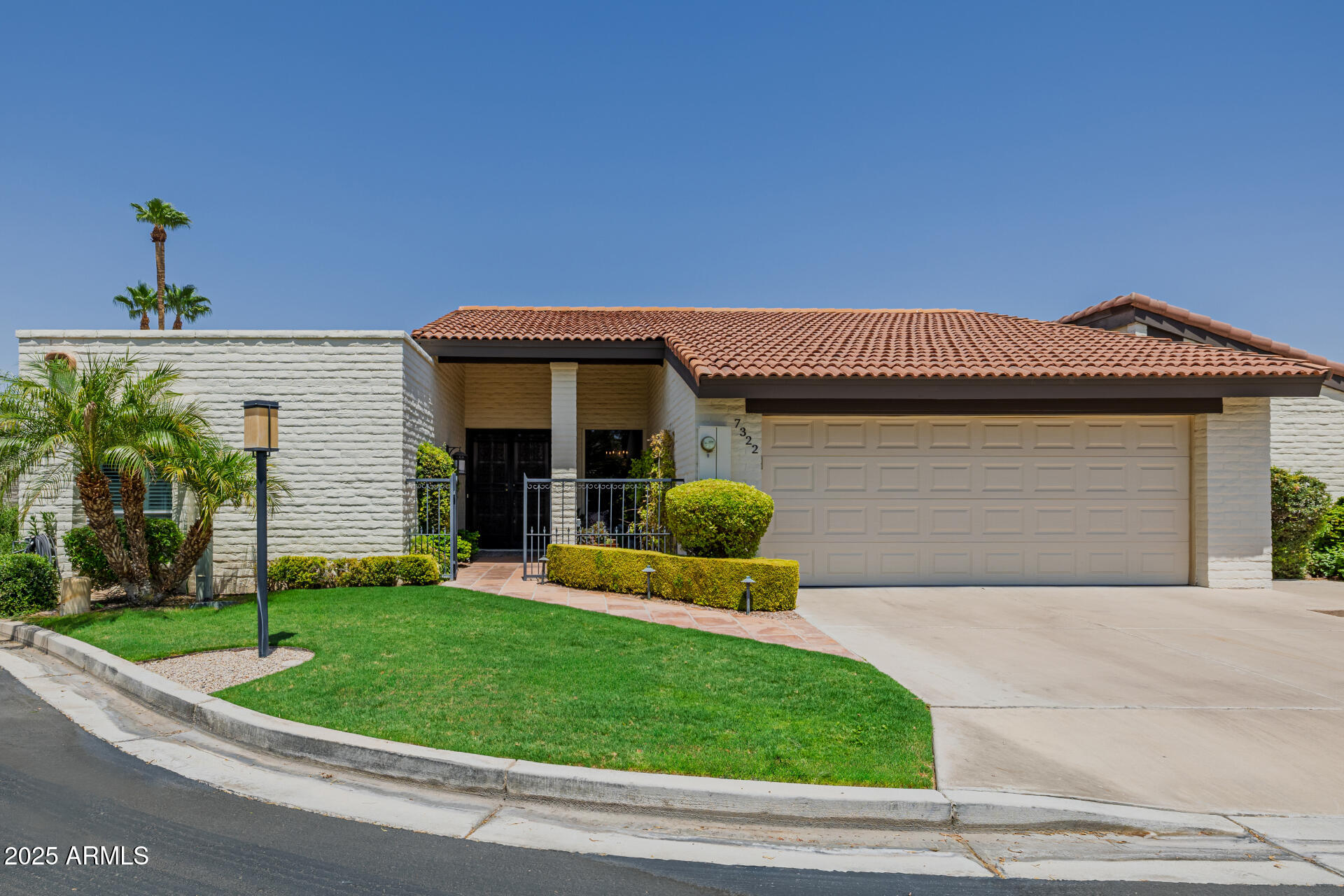 7322 East McLellan Boulevard Scottsdale, AZ 85250 - Photo 2 of 64 a front view of a house with a yard and garage