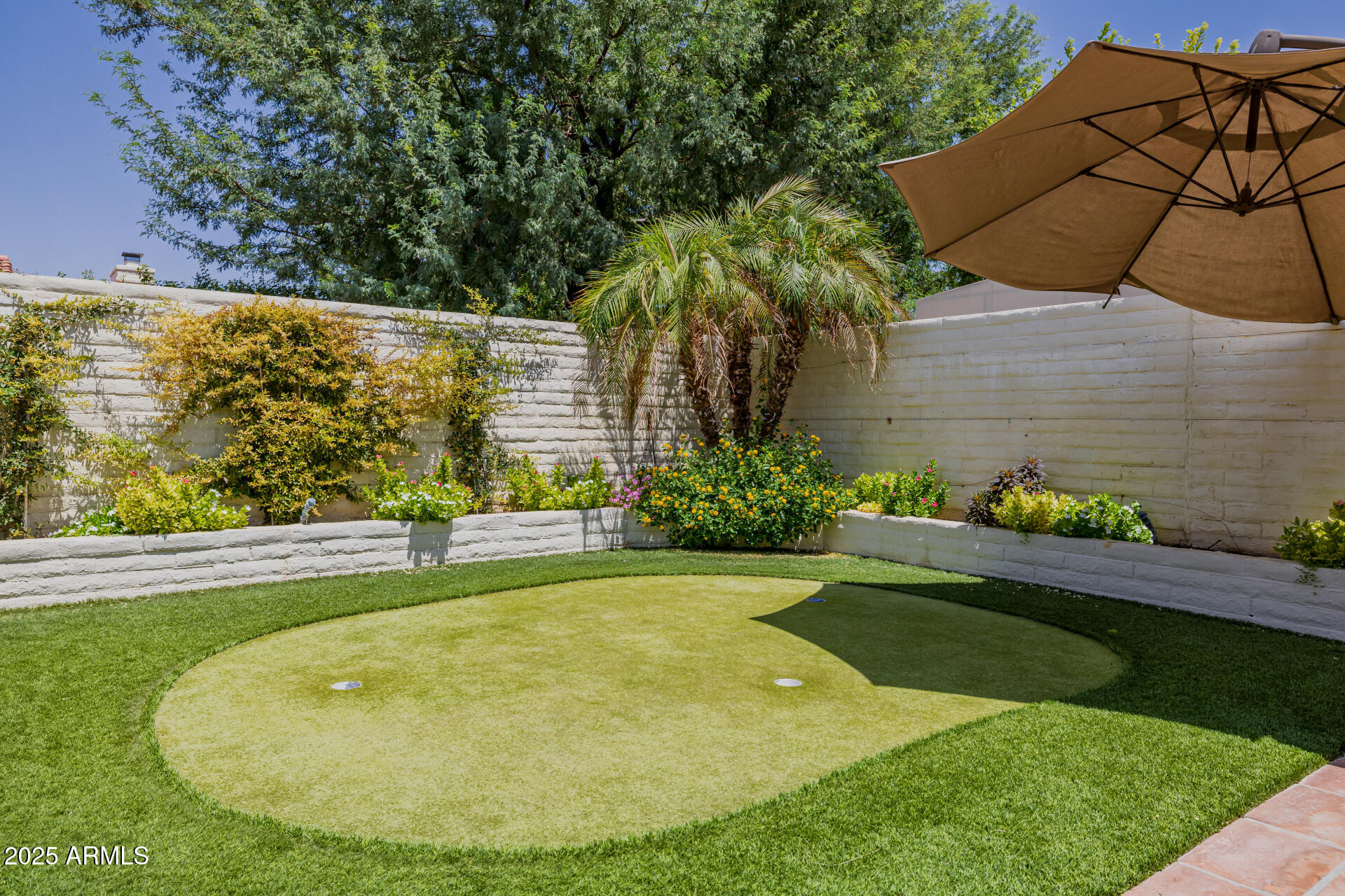 7322 East McLellan Boulevard Scottsdale, AZ 85250 - Photo 51 of 64 a view of a backyard with table and chairs under an umbrella