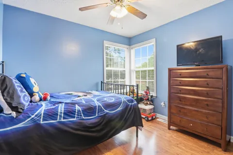a bedroom with a bed and wooden floor