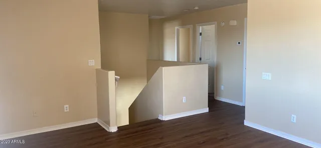 an empty room with wooden floor and entrance