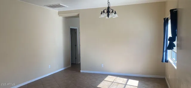 an empty room with windows and cabinet