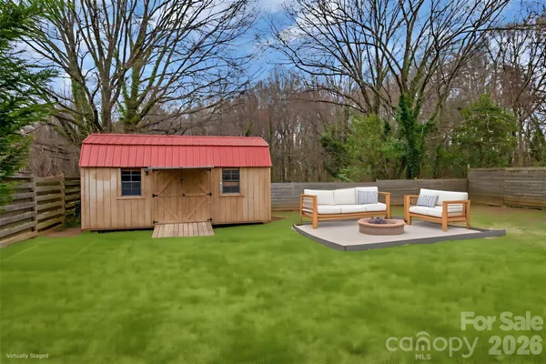 a view of a backyard with table and chairs under an umbrella