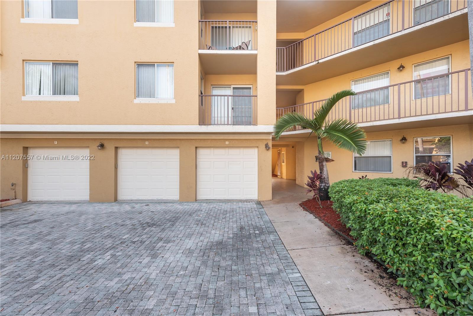 771 North Pine Island Road, Unit 203 Plantation, FL 33324 - Photo 17 of 20 a front view of a house with a yard and garage
