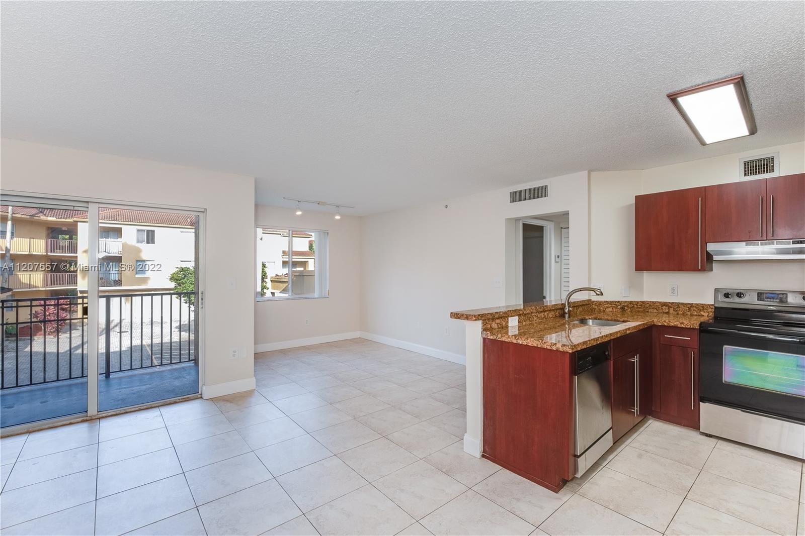 771 North Pine Island Road, Unit 203 Plantation, FL 33324 - Photo 5 of 20 a kitchen with stainless steel appliances granite countertop a stove a sink and a microwave