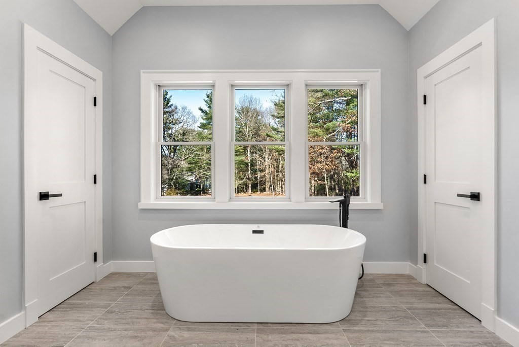 162 Winter Street Weston, MA 02493 - Photo 24 of 36 a white bath tub sitting in a bathroom next to a window
