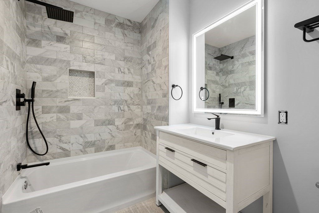 162 Winter Street Weston, MA 02493 - Photo 26 of 36 a bathroom with a granite countertop sink a mirror and a bathtub