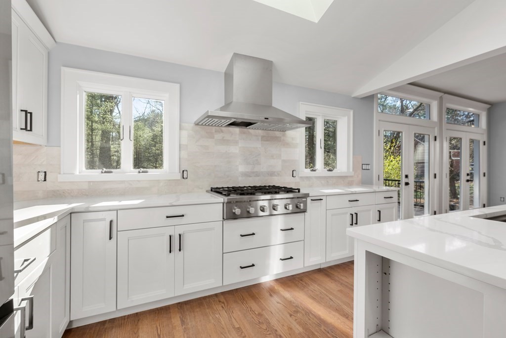 162 Winter Street Weston, MA 02493 - Photo 5 of 36 a kitchen with stainless steel appliances a stove a sink and white cabinets with wooden floor