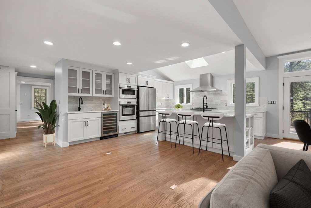 162 Winter Street Weston, MA 02493 - Photo 6 of 36 a kitchen with stainless steel appliances kitchen island granite countertop a stove top oven a sink a refrigerator with white cabinets and wooden floor