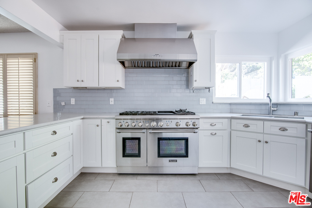 8204 Pershing Drive Playa del Rey, CA 90293 - Photo 6 of 27 a kitchen with granite countertop white cabinets and white stove