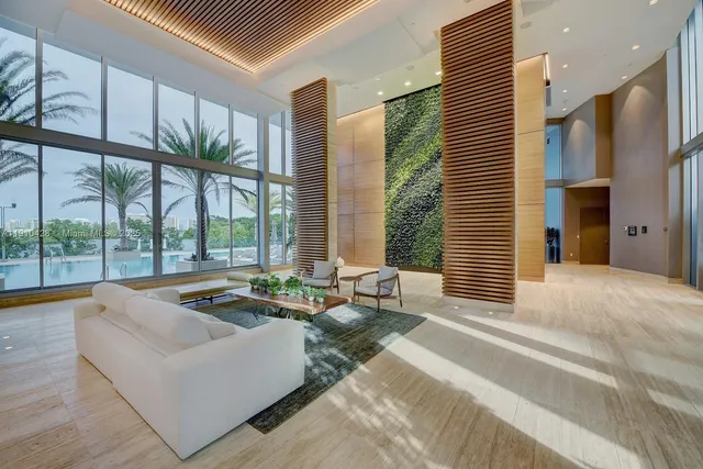 a living room with furniture fireplace and large windows