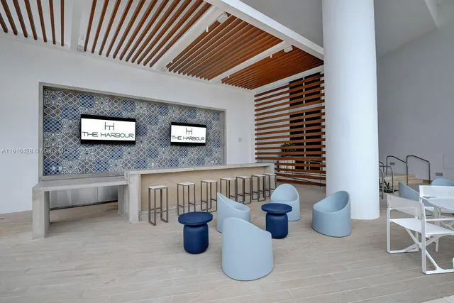 a living room with furniture and floor to ceiling windows