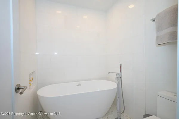 a white bath tub sitting next to a white toilet