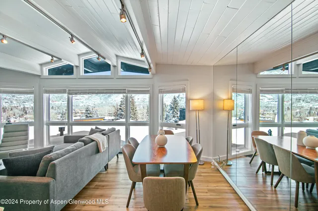 a kitchen with a stove a sink and a dining table with garden view