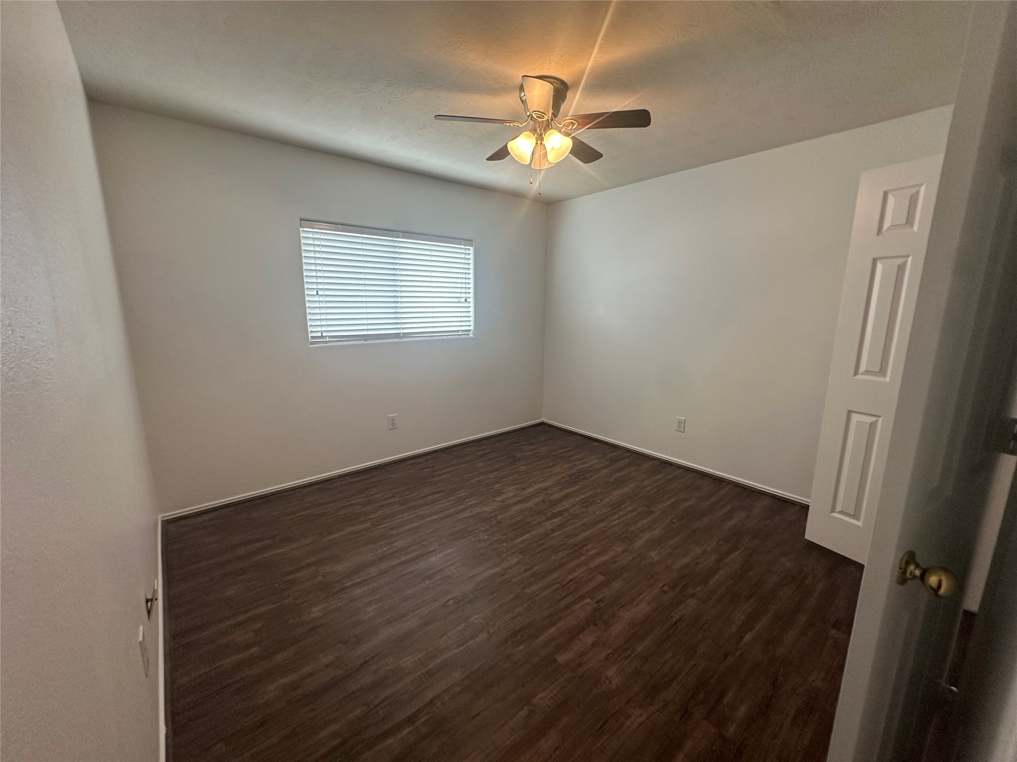 10331 Ravenwood View Lane Houston, TX 77075 - Photo 8 of 11 an empty room with wooden floor and fan