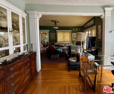 a living room with furniture a flat screen tv and kitchen view