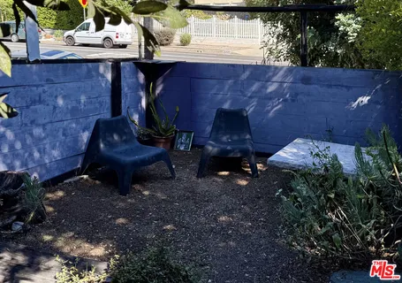 a vase with flowers sitting on a table in front of a house