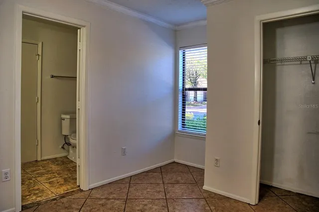 a view of an empty room with a bathroom and a window