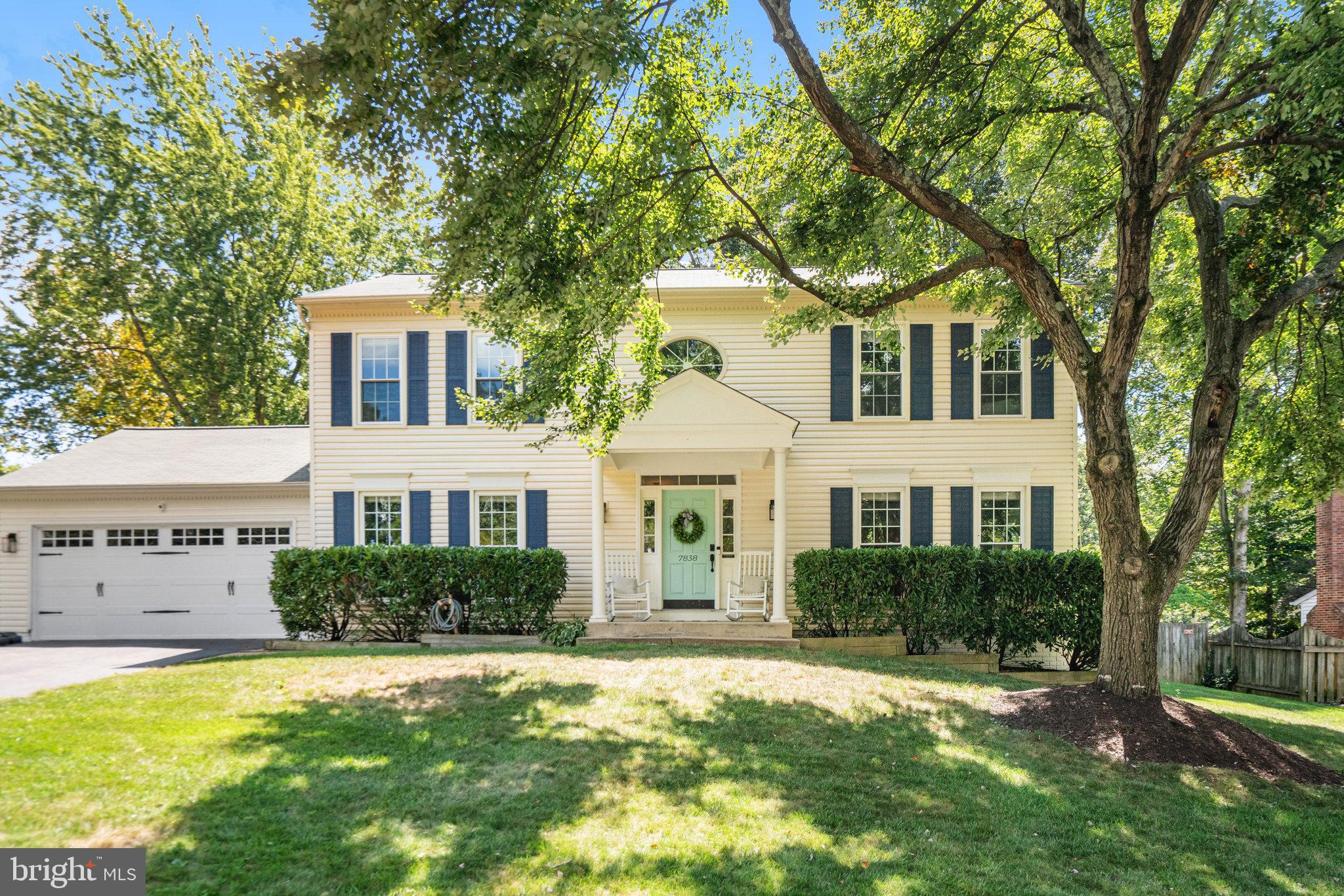 a front view of a house with a yard and trees
