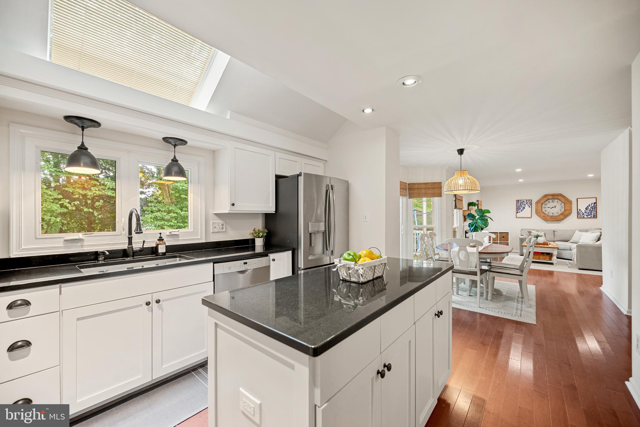 7838 Roundabout Way Springfield, VA 22153 - Photo 6 of 56 a kitchen with a sink dishwasher white cabinets and couches with wooden floor