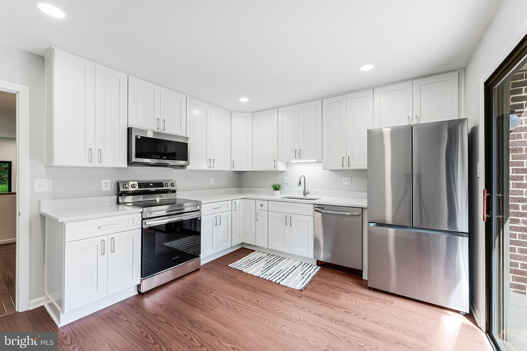 12023 Insha Court Reston, VA 20191 - Photo 22 of 52 a kitchen with a refrigerator stove and wooden cabinets