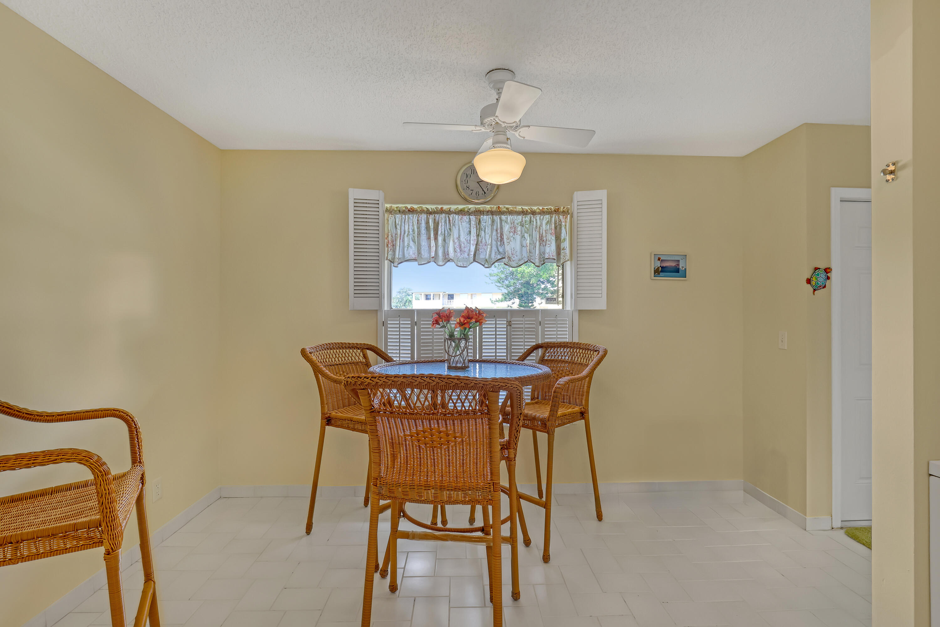 1850 Northwest 18th Street, Unit 103 Delray Beach, FL 33445 - Photo 11 of 28 a view of a dining room with furniture and a chandelier